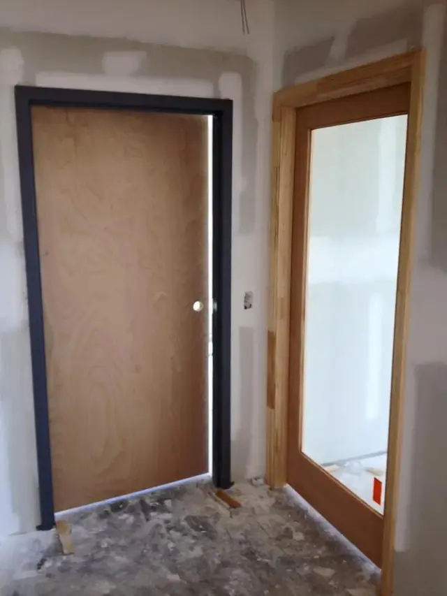 Birch flush door and a wood door with glass, photographed during construction