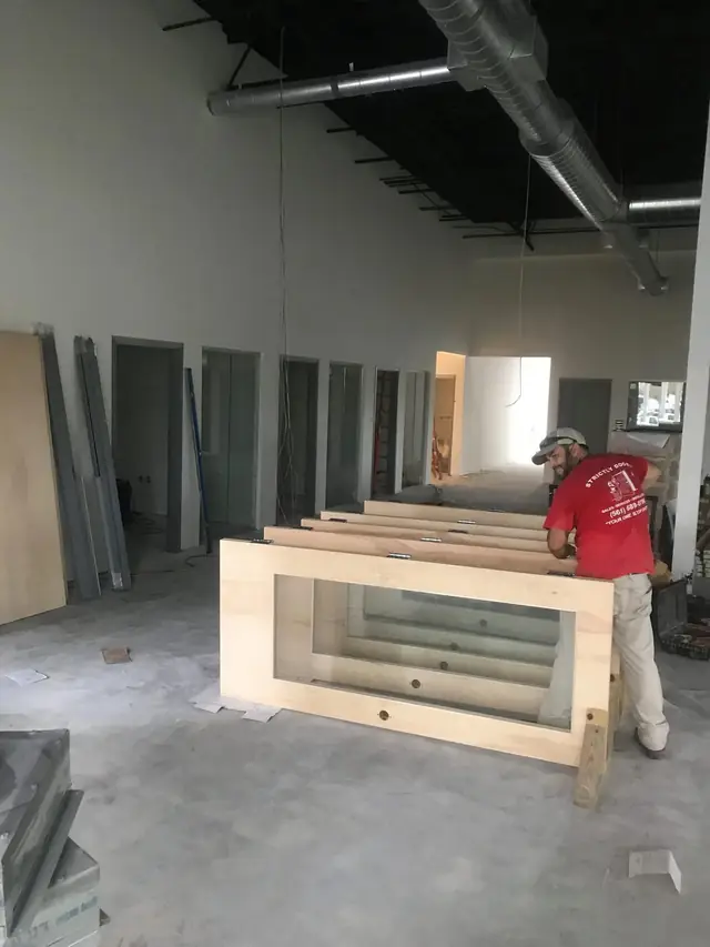 A Strictly Doors installer setting door slabs during a commercial build-out
