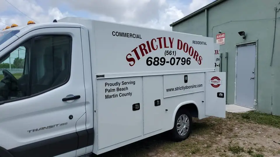White Strictly Doors service van lettered for commercial and residential work